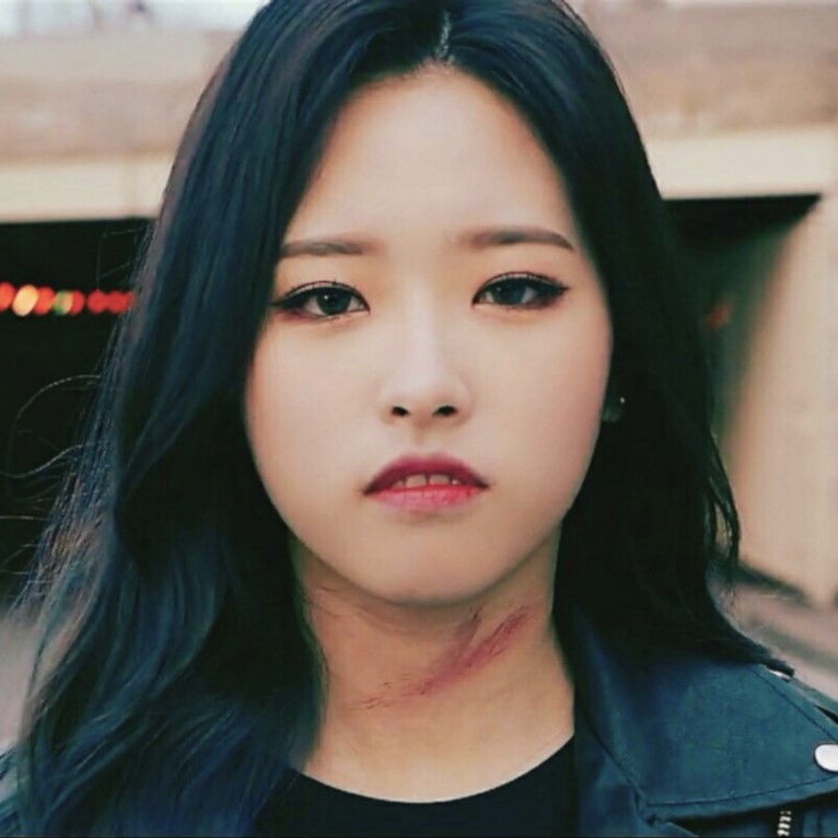 Olivia Hye from the 'XIIIX' teaser. She has long black hair and is wearing a black jacket. She is staring at the viewer. There is a large scrape on her neck.